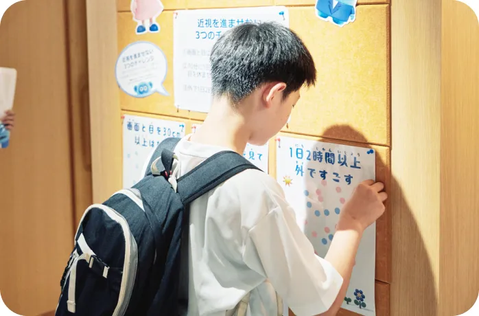 ボードにシールを貼る子ども