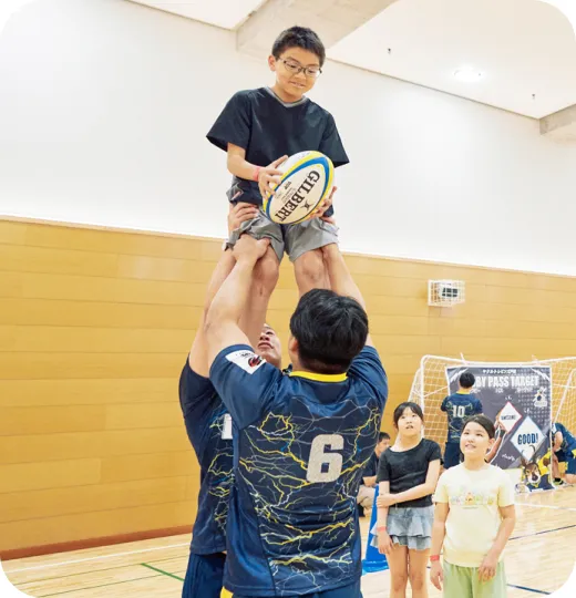 選手が子どもをリフトアップする様子