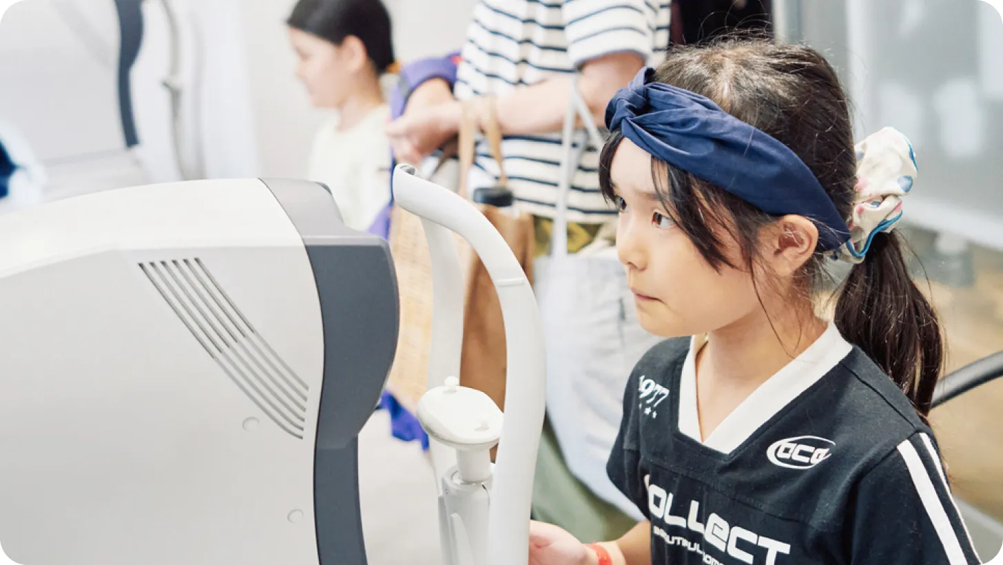 オートレフケラトメーターで視力検査を体験する子ども